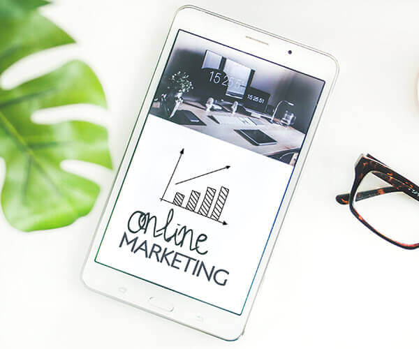 Tablet on a table with online marketing text on it